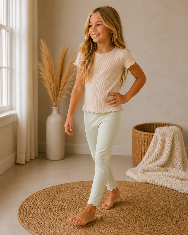 Young girl standing in a room with a vase and basket in the background