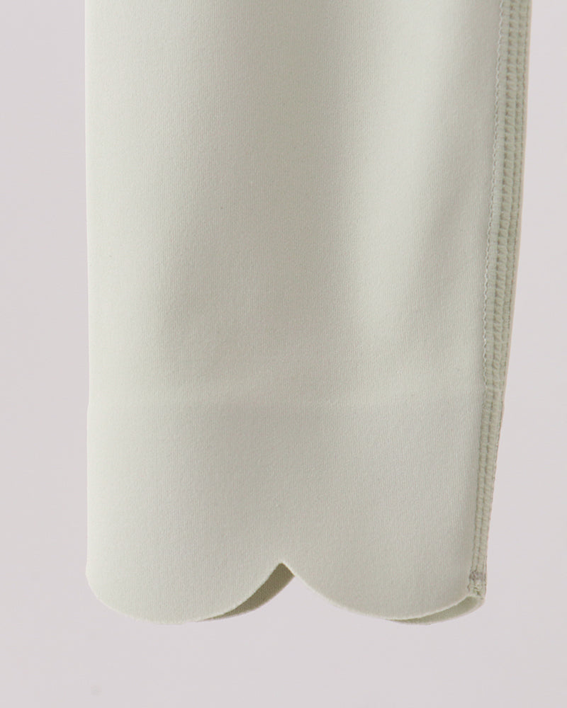 Close-up of a light-colored garment on a plain background