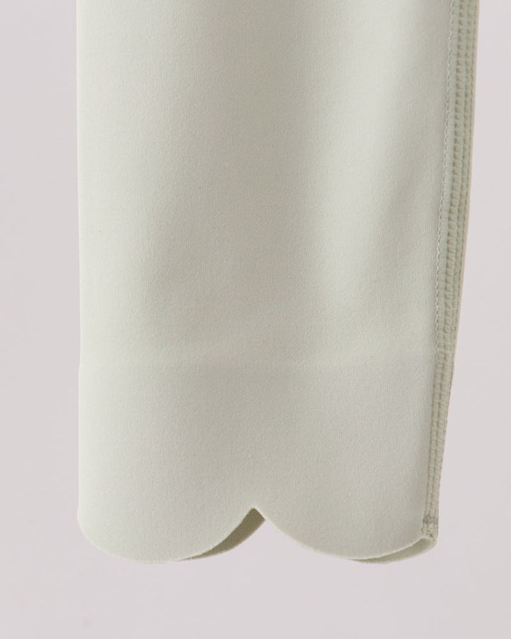 Close-up of a light-colored garment on a plain background
