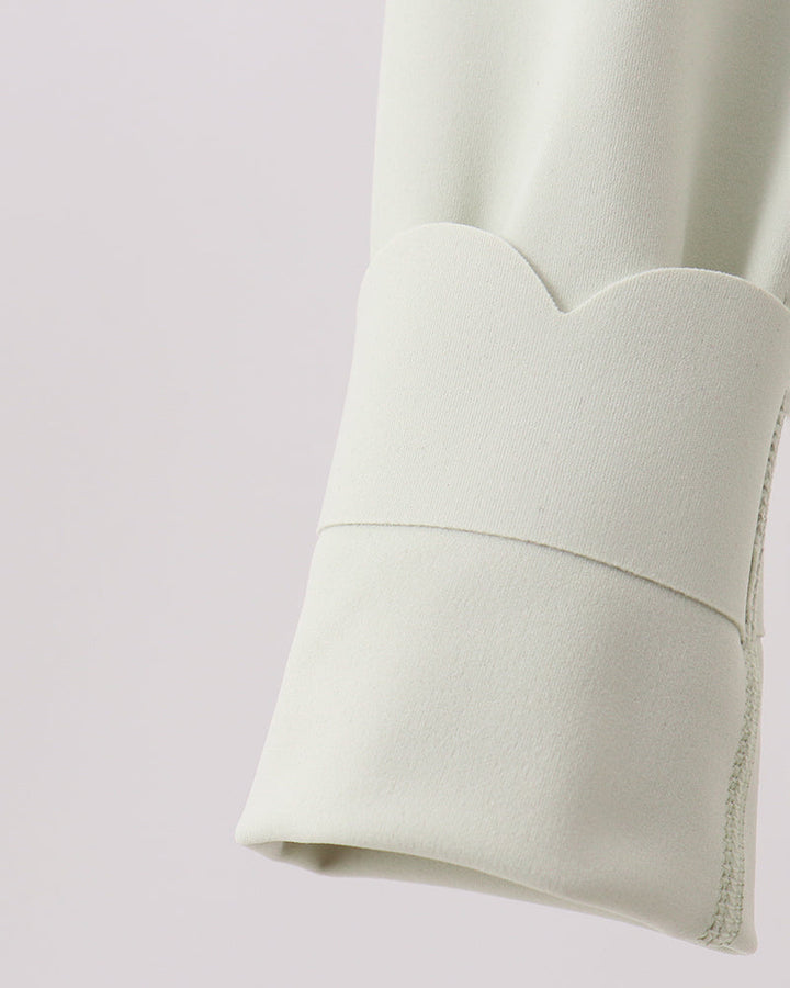 Close-up of a light green fabric with a subtle pattern on a light purple background