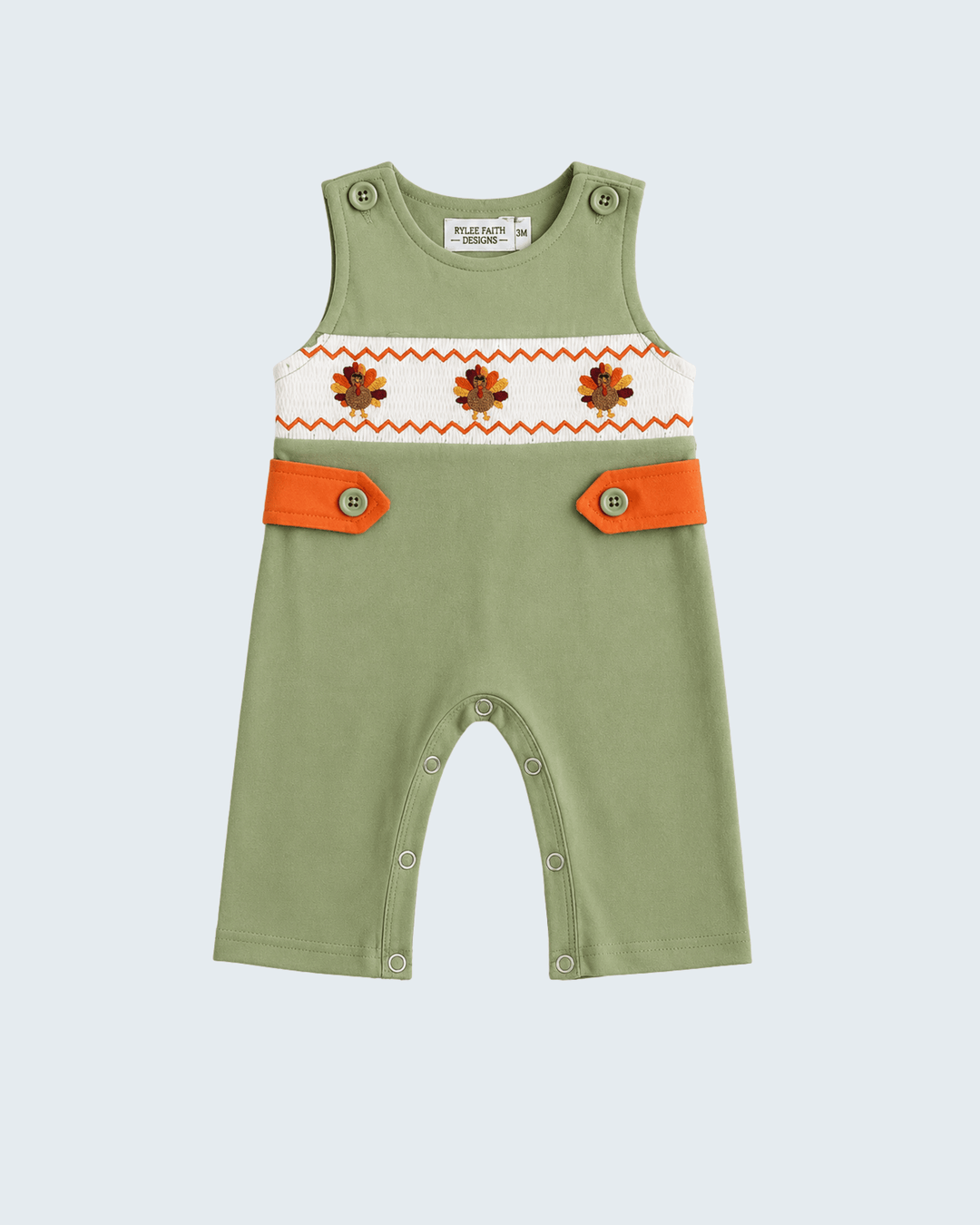 Green embroidered romper with orange yoke trim, button tabs, and snap leg opening