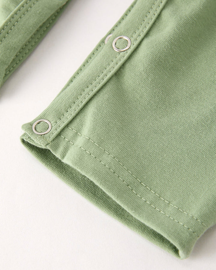 Green romper snap-tab closure with stitched placket and metal ring details