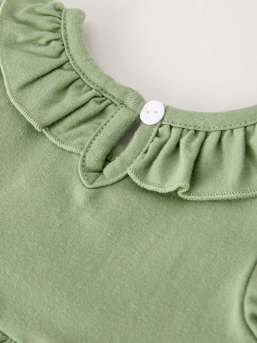 Green romper with gathered ruffled collar and button closure