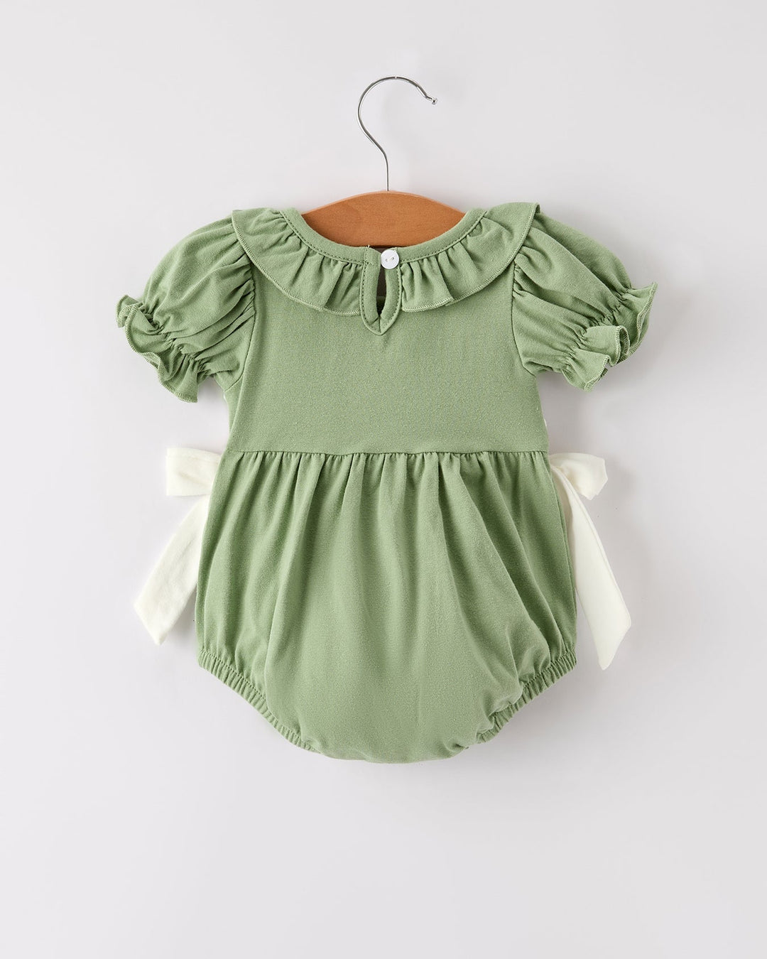 Green smocked romper with puff sleeves and ruffled neckline