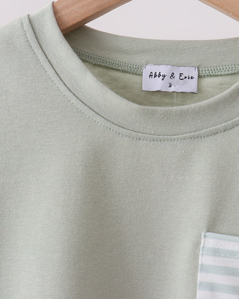 Light green t-shirt with a brand label on a hanger