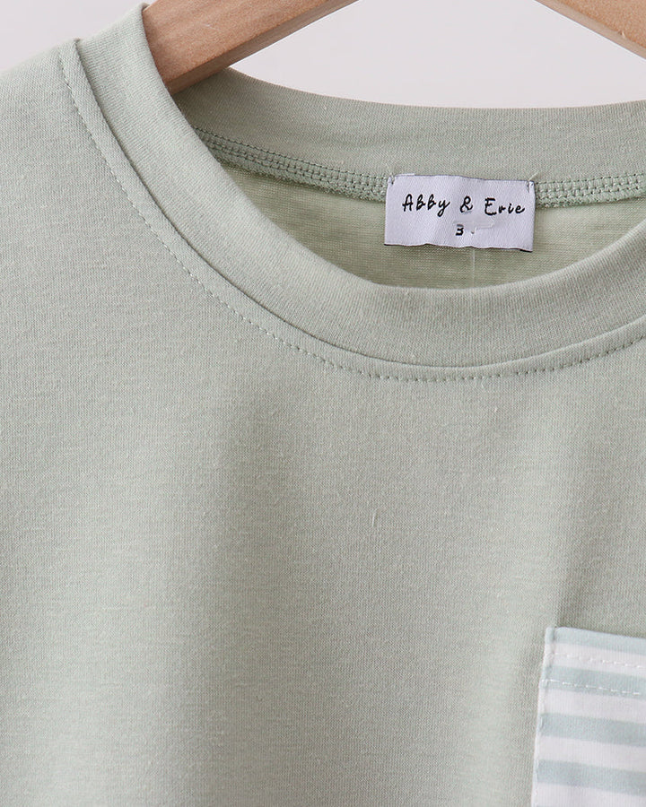 Light green t-shirt with a brand label on a hanger