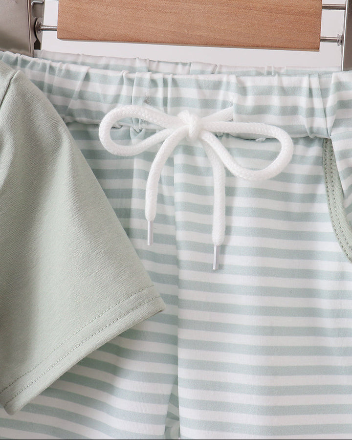 Striped shorts with a drawstring on a hanger against a neutral background