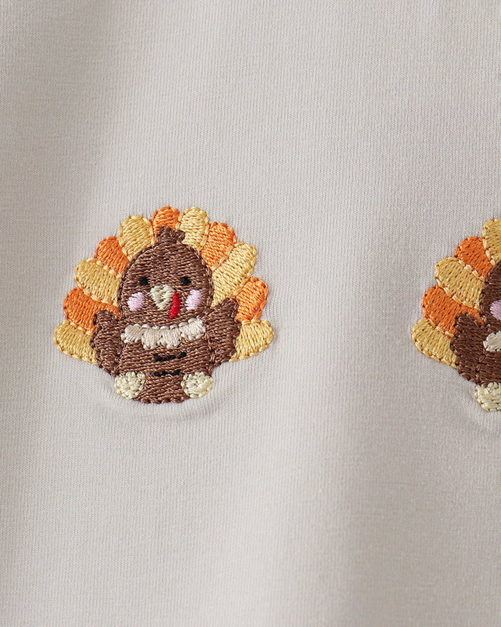 Embroidered turkey face patch on light fabric