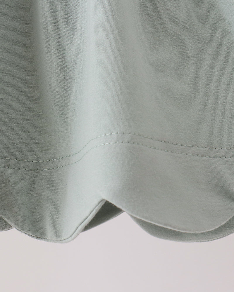 Mint green tunic hem with scalloped edge and double-stitched seam