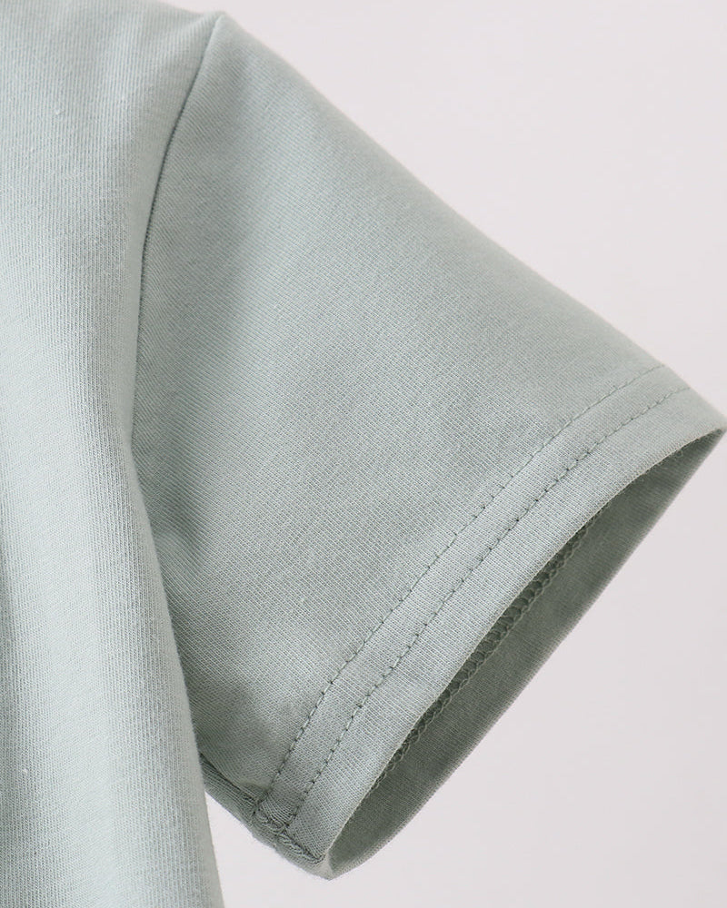Close-up of a light gray fabric sleeve on a plain background