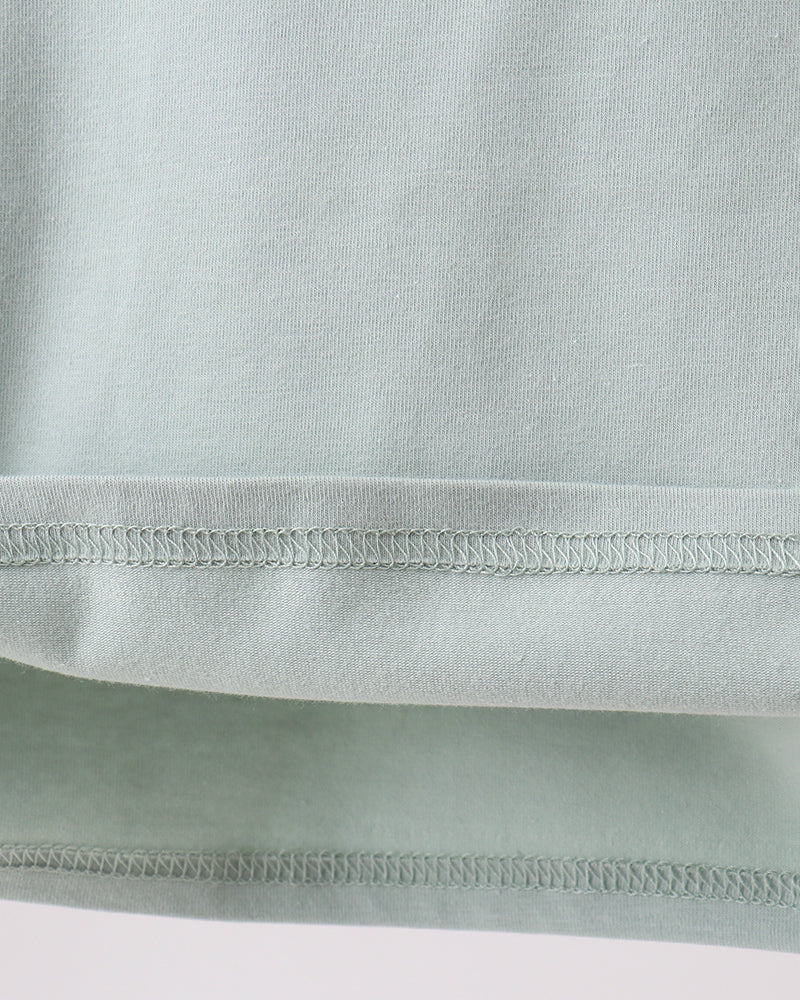 Close-up of a light green fabric with a focus on texture and stitching.