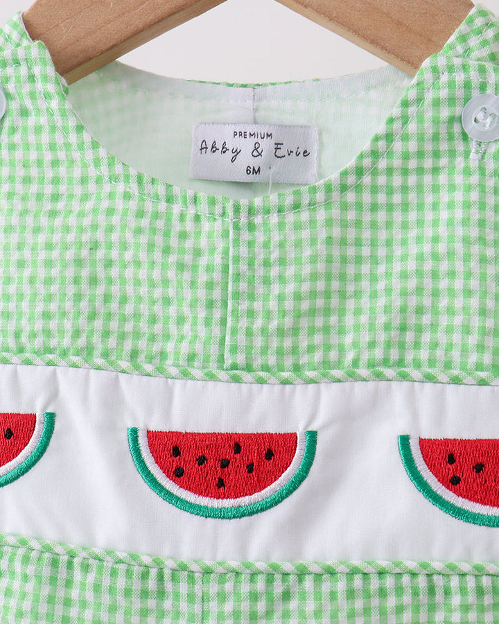 Green checkered dress with watermelon design on a hanger