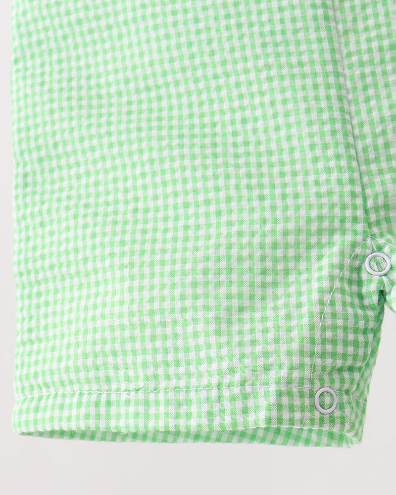 Green and white checkered shirt with buttons on a light gray background