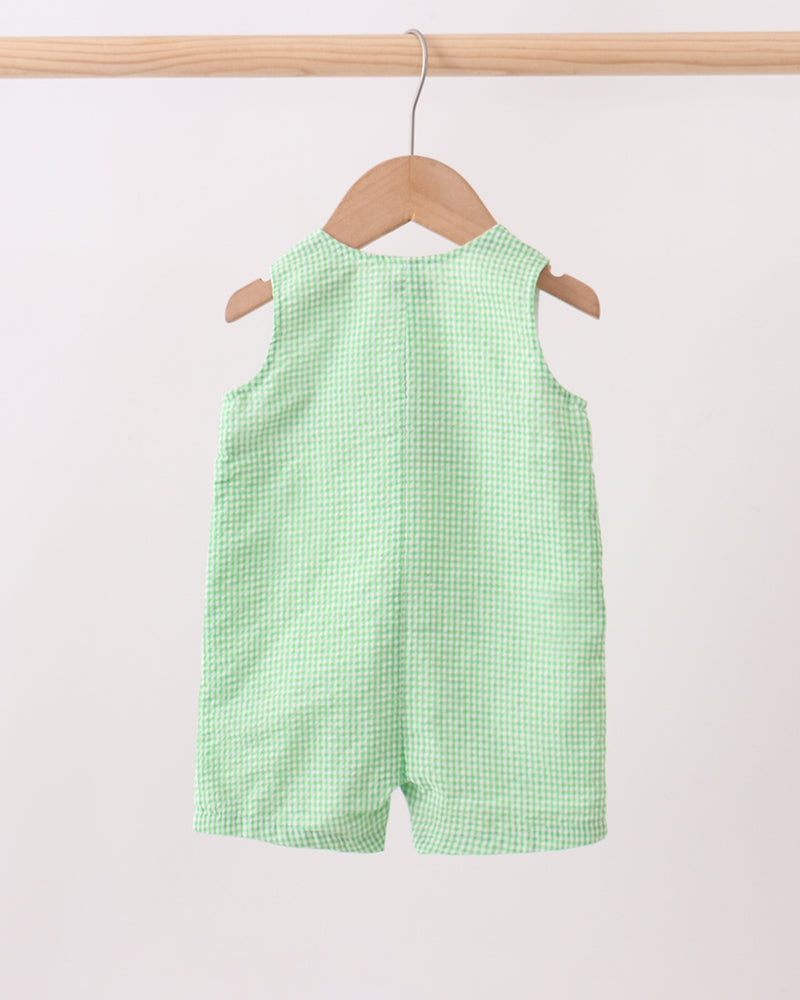 Green checkered shorts on a hanger against a white background