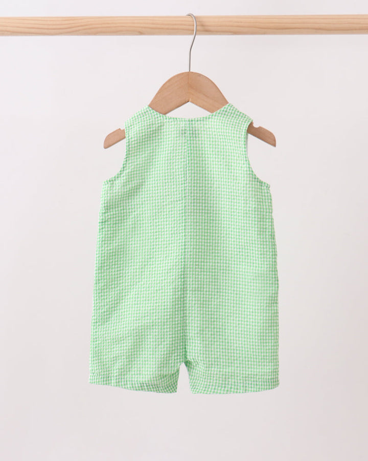 Green checkered shorts on a hanger against a white background