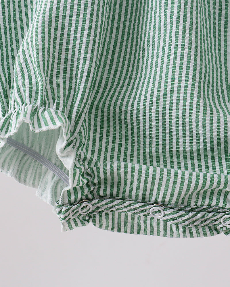 Green and white striped fabric with ruffled edge on a light gray background