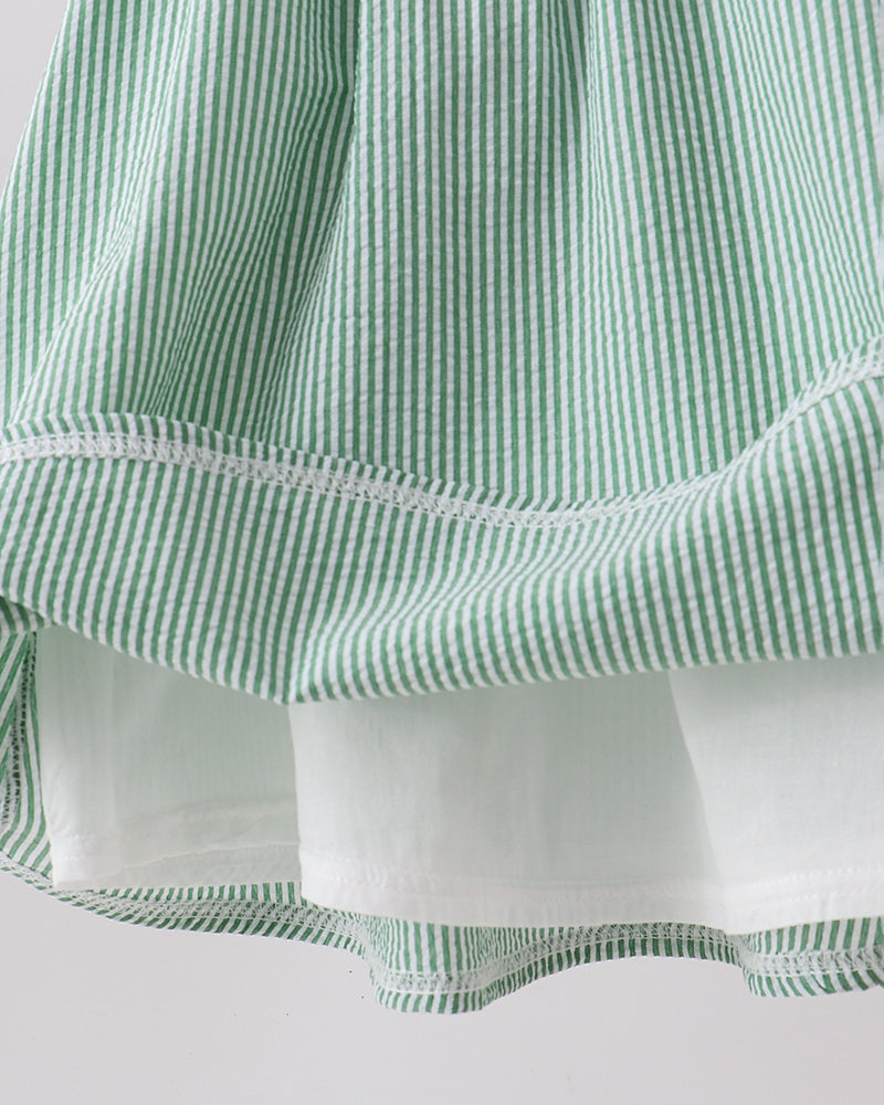 Close-up of a green and white striped fabric with a plain background