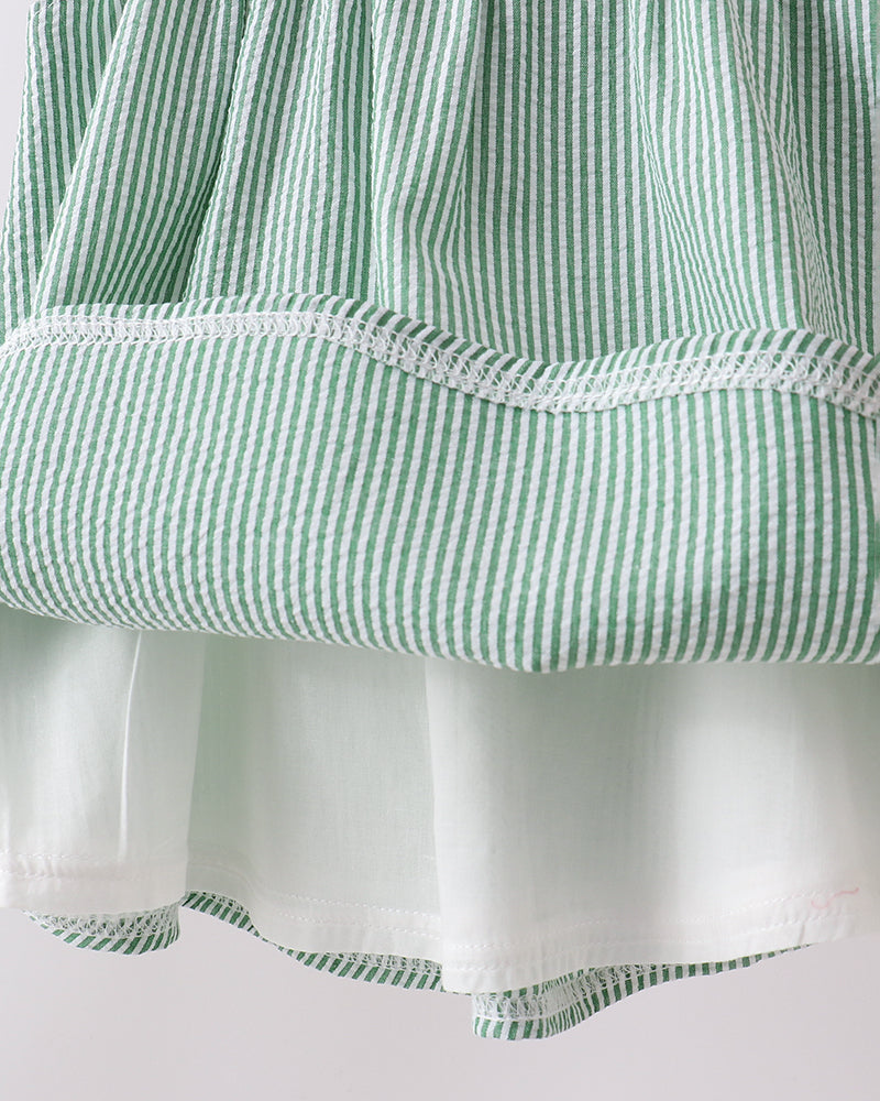 Close-up of a green and white striped fabric with a plain background
