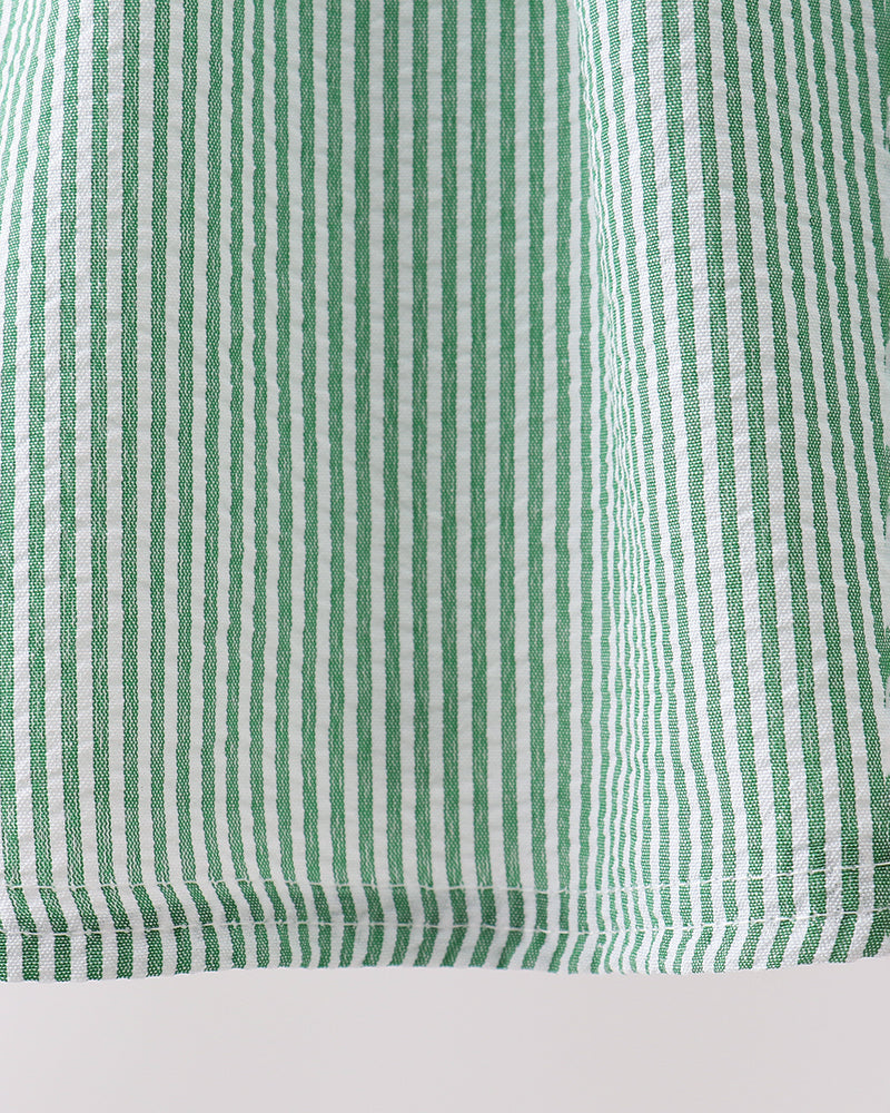 Close-up of green and white striped fabric on a light gray background