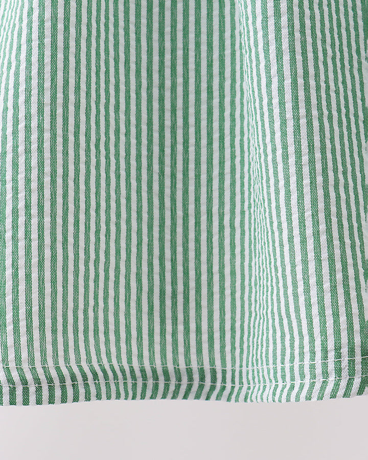 Close-up of green and white striped fabric on a light gray background