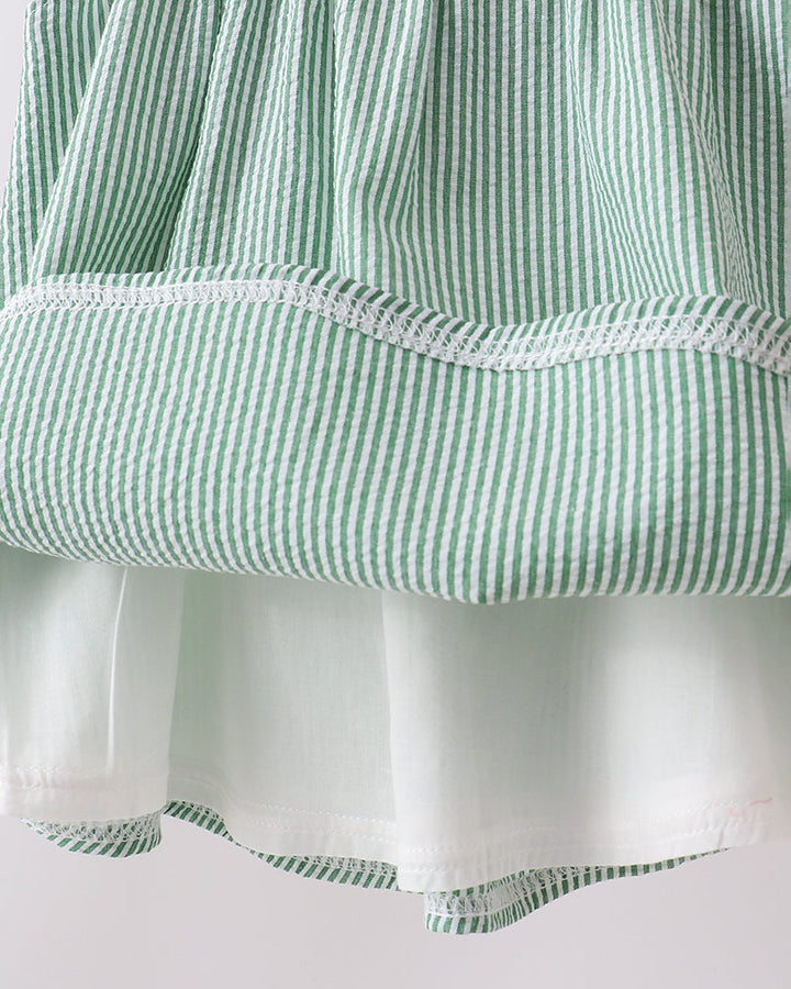 Close-up of a green and white striped fabric with a plain background