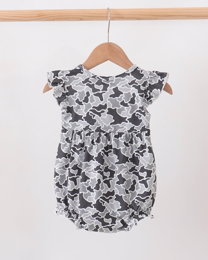 A baby romper with a gray and black camouflage pattern, featuring ruffled cap sleeves and a ruffled bloomers hem, hanging on a wooden hanger against a plain white background.