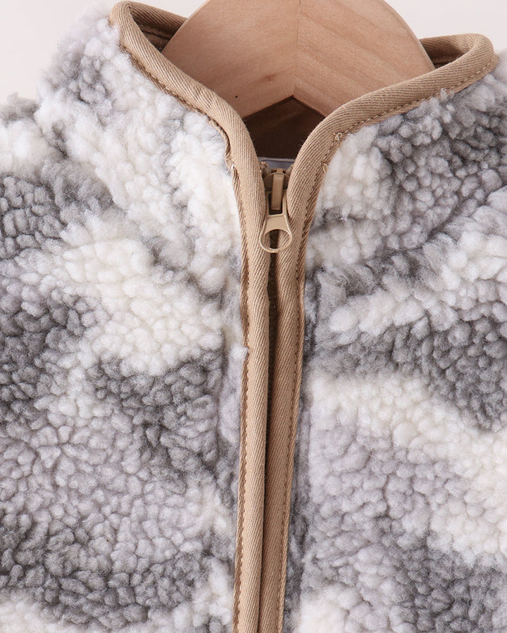 Close-up of a sherpa fleece zip-up jacket in a gray and white pattern, hanging on a wooden hanger.