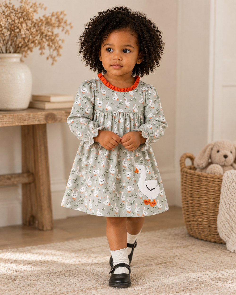 Grey Goose girl’s long-sleeve dress with swan print, orange ruffle trim, and appliqué