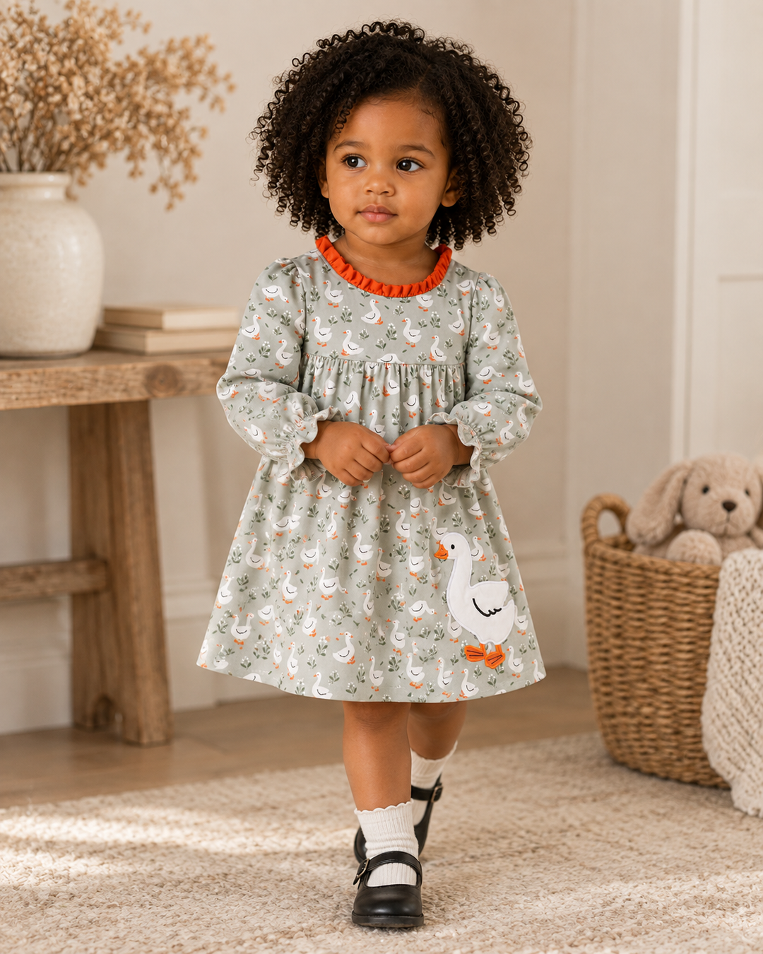 Grey Goose girl’s long-sleeve dress with swan print, orange ruffle trim, and appliqué