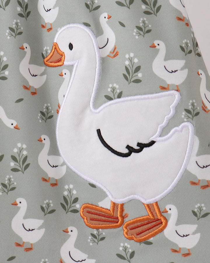Goose applique detail on grey goose print dress with orange accents