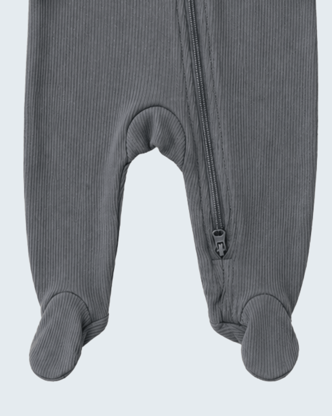 Close-up of a gray ribbed footed sleeper or one-piece with a front zipper, showing the leg and foot sections against a light gray background.