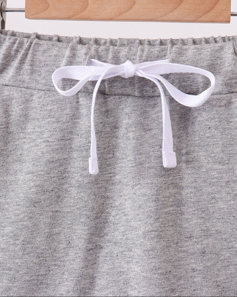 Grey skort with elastic waist, white bow ties, and scalloped hem