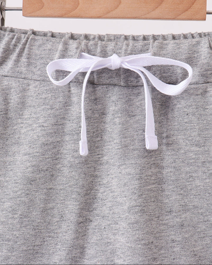 Grey skort with elastic waist, white bow ties, and scalloped hem