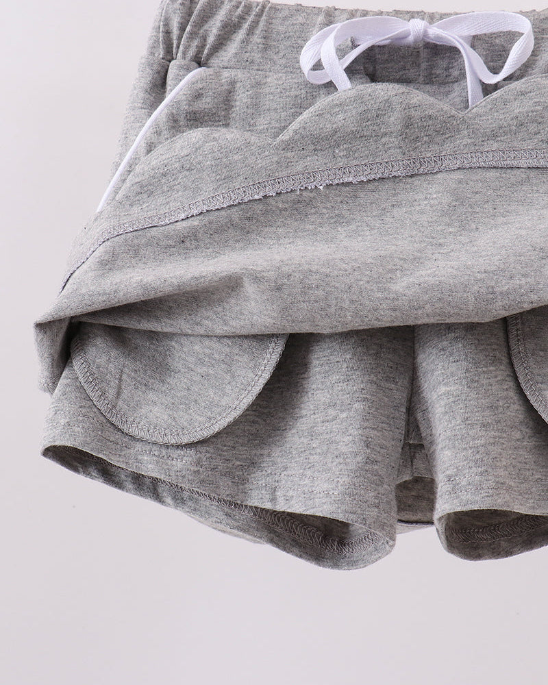 Grey skort showing scalloped hem and bow-tie waistband