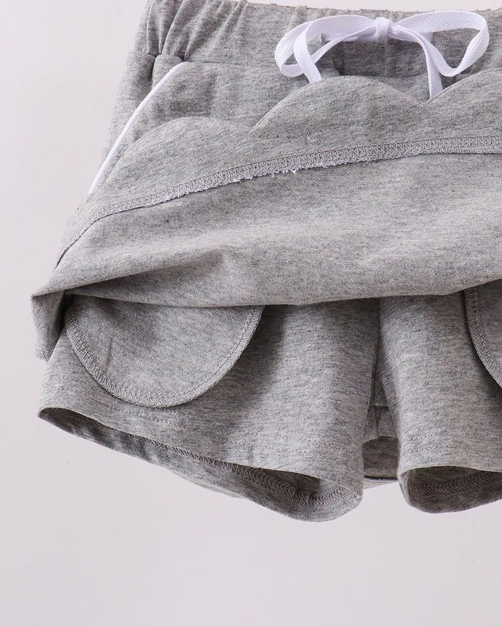 Grey skort showing scalloped hem and bow-tie waistband