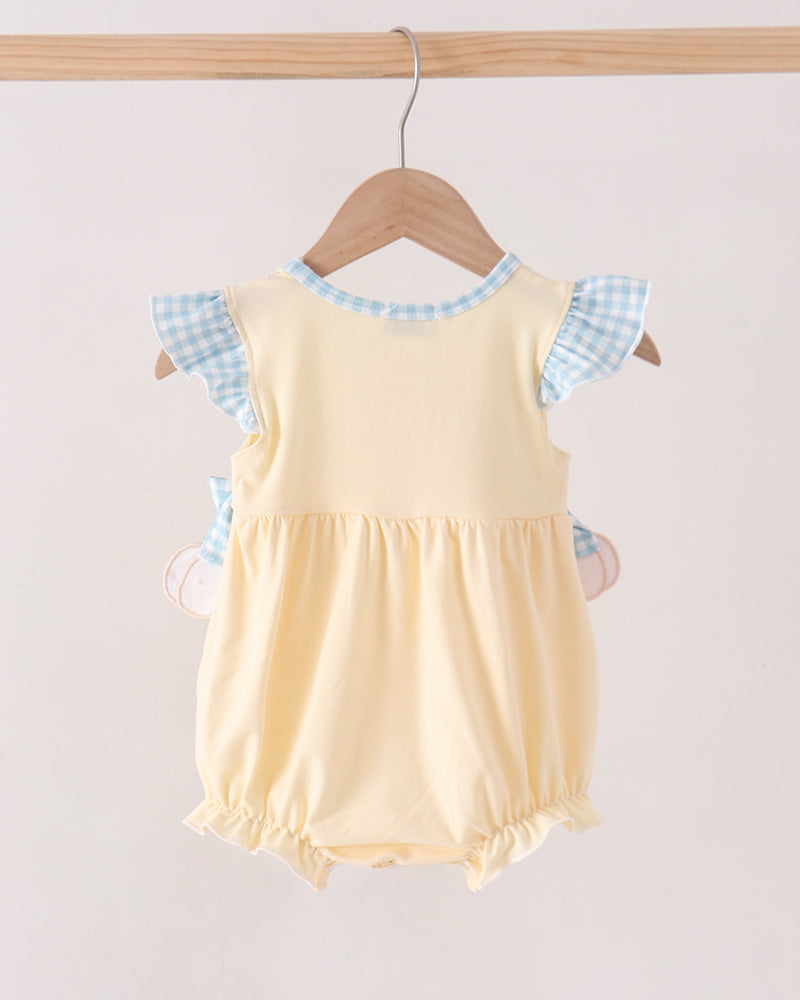 A baby romper in pale yellow with light blue and white gingham checkered flutter sleeves, hanging on a wooden hanger against a light beige background.