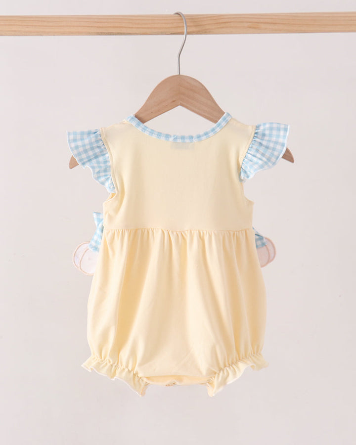 A baby romper in pale yellow with light blue and white gingham checkered flutter sleeves, hanging on a wooden hanger against a light beige background.