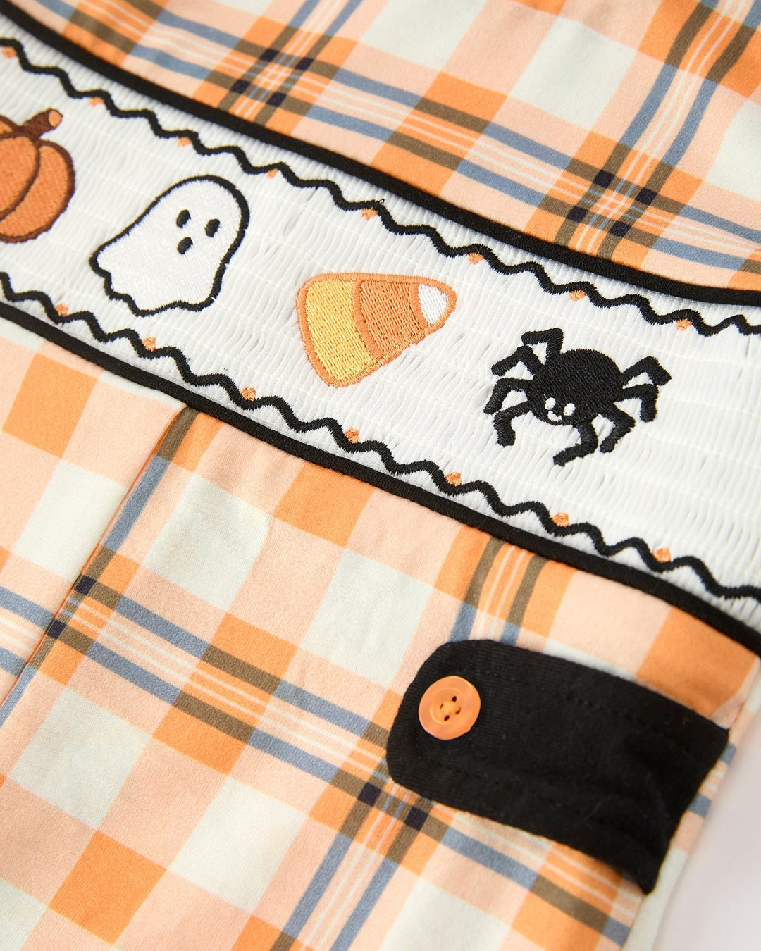 Plaid romper placket with ghost, cat, pumpkins, black trim, and orange buttons