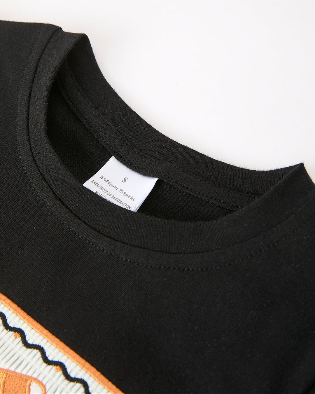 Black boys T-shirt with crew neck collar; fabric close-up