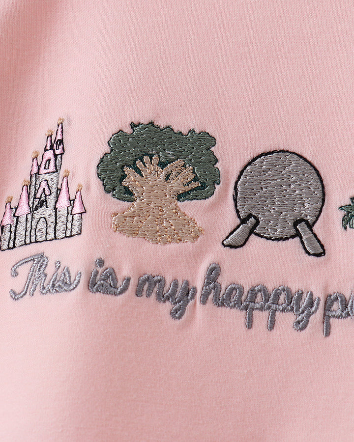Embroidered design on a pink fabric with castle, tree, and ping pong table, and text &