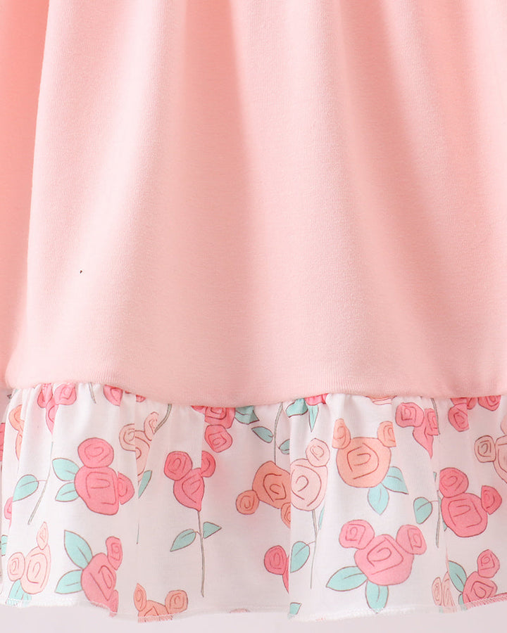 Pink fabric with floral patterned trim on a white background