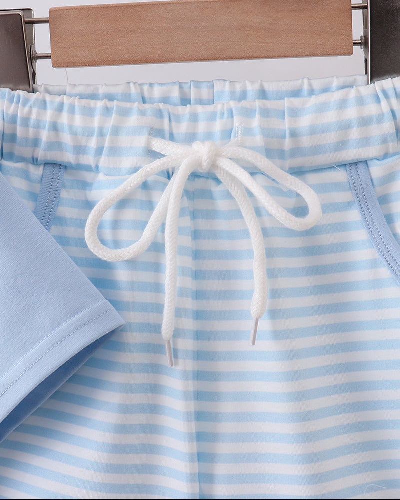 Blue and white striped shorts with a drawstring on a hanger against a light background