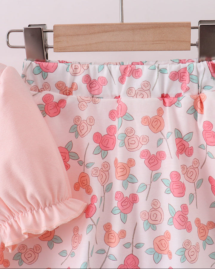 Floral-patterned fabric on a hanger with a pink garment underneath.