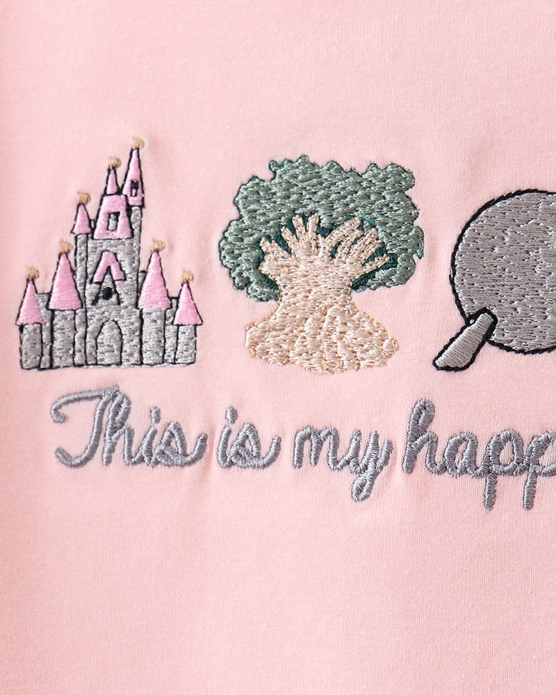 Embroidered design on a pink background with castle, tree, and speech bubble.