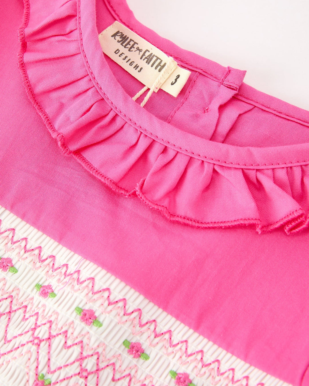 Girls hot pink dress with ruffled neckline and embroidered smocked yoke