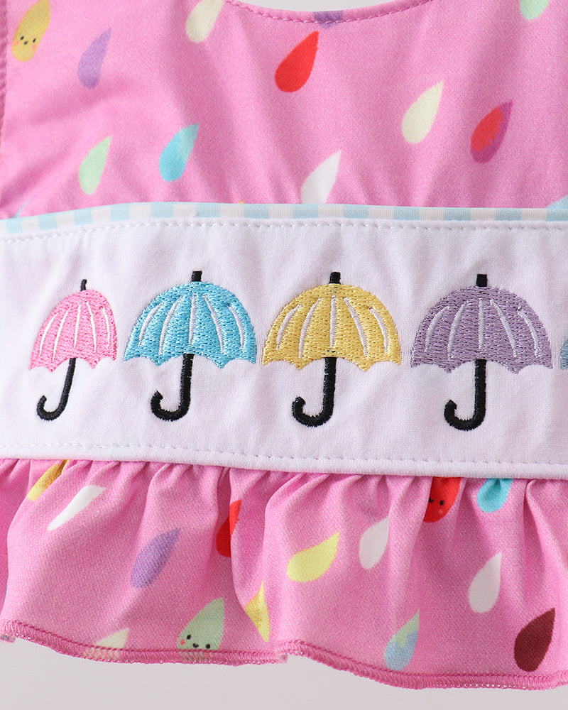 Pink swimsuit with colorful umbrella pattern on a white background