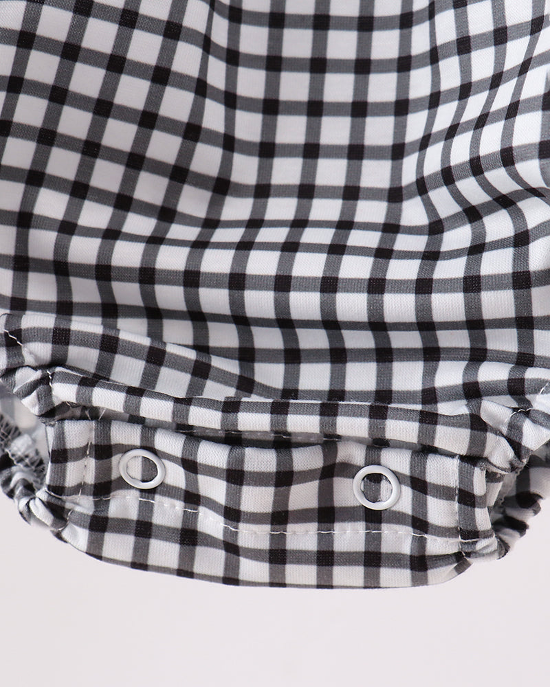 Black and white checkered fabric with button details on a light gray background