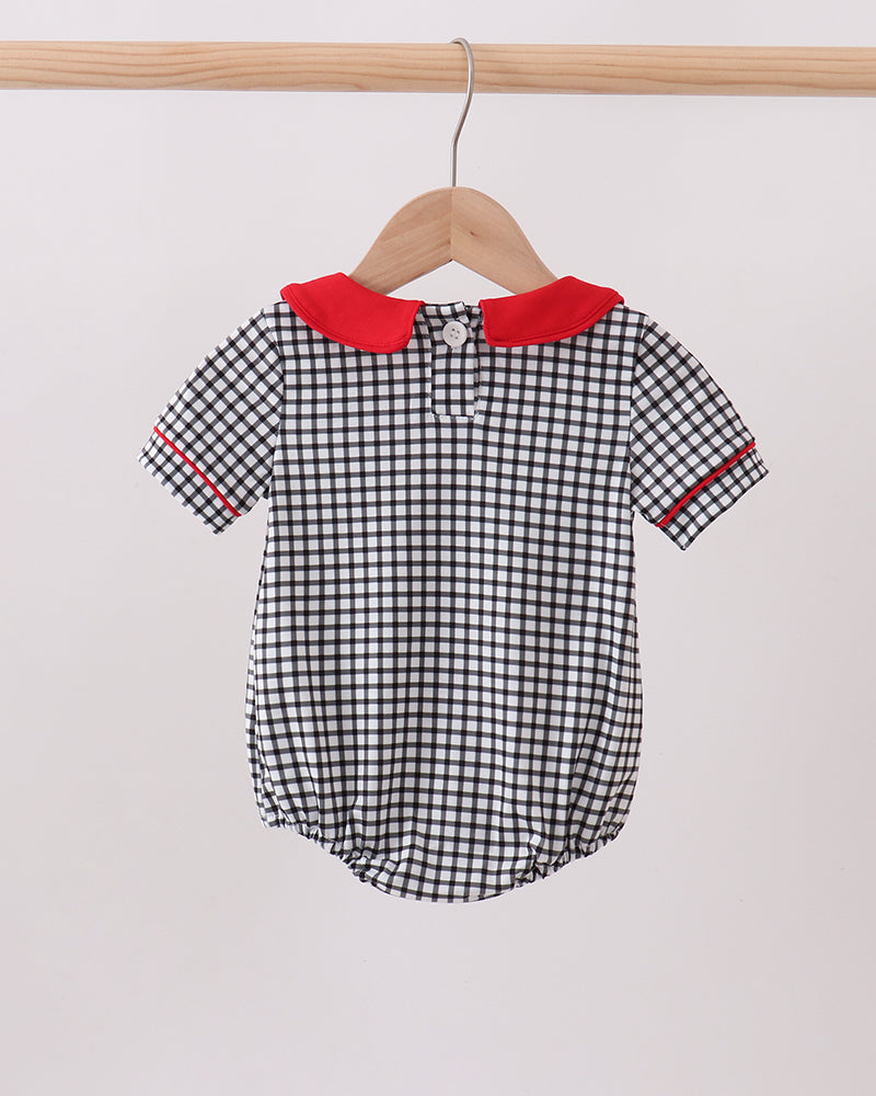 Black and white checkered baby romper with red trim on a hanger against a white background