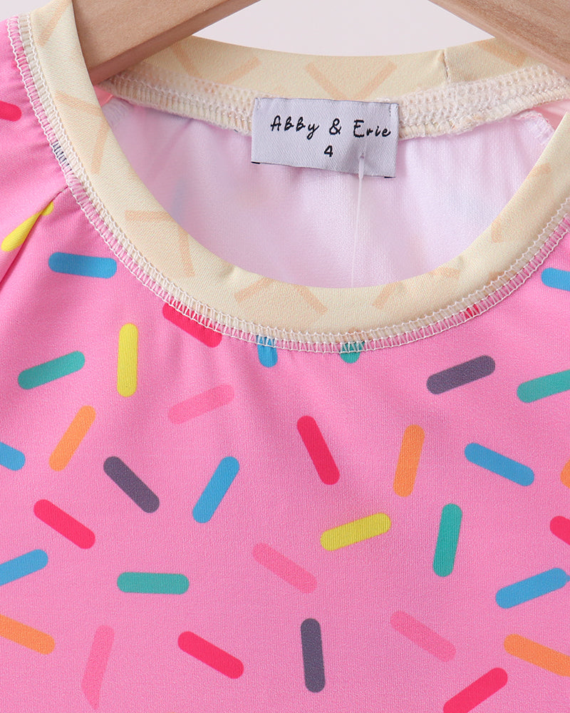 Pink swimsuit with colorful sprinkles and &