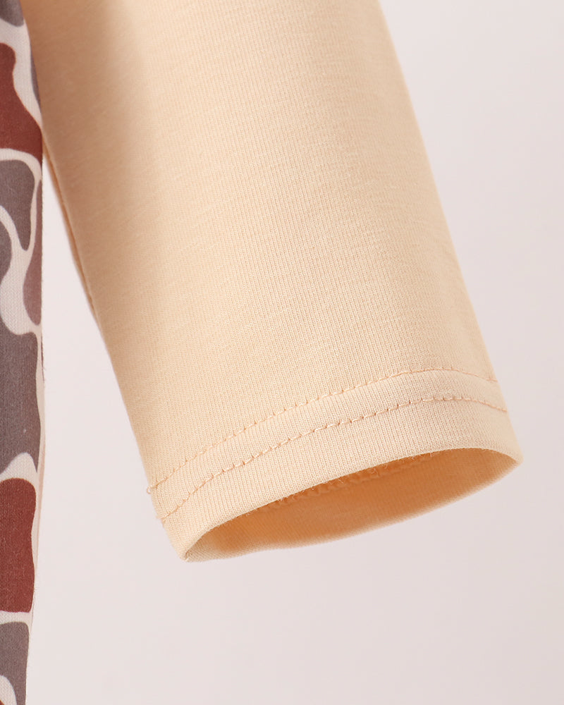 Close-up detail of a beige ribbed knit sleeve with a clean hem, shown against a plain light background.